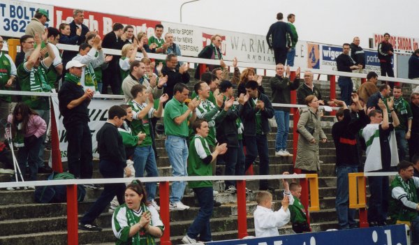 The travelling supporters celebrate being top of the league