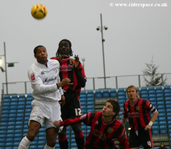 Kevin Amankwaah leaps high for the ball as Arron Davies and Terry Skiverton look on