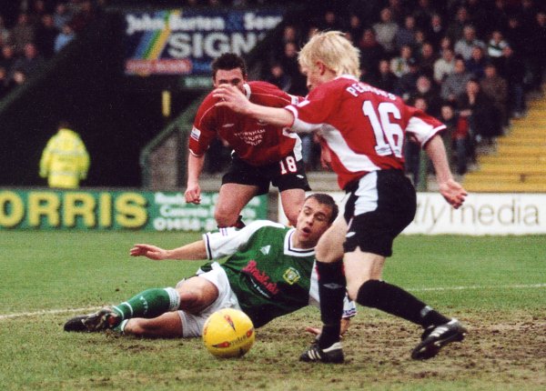Andy Lindegaard attempts to get a boot on the ball as Morecambe's David Perkins aims to clear his penalty box