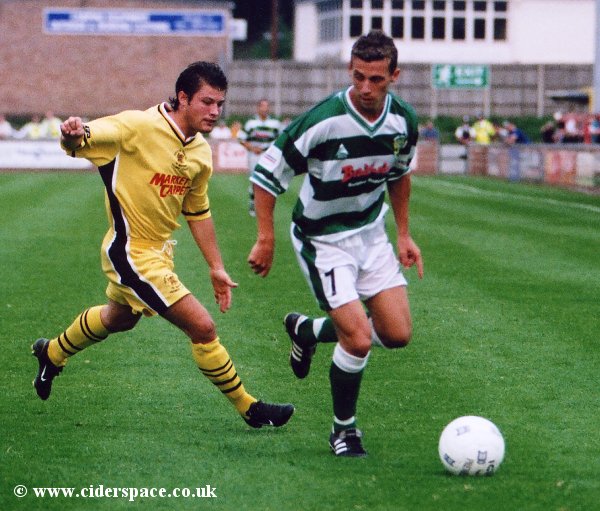 Adam Stansfield holds possession from a Tiverton defender