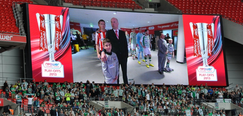Glovers fans wait the start of the match underneath a giant video screen. Photo c/o Yeokel.